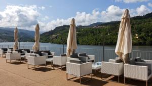 里巴多鲁杜罗河谷皇家酒店&Spa的庭院里摆放着一组椅子和遮阳伞