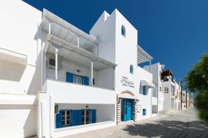 纳克索乔拉Fragias Studios & Apartments的白色的建筑,街道上设有蓝色的门
