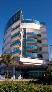 马卡埃马卡埃康福特套房酒店的前面有棕榈树的建筑