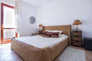 斯廷蒂诺villa sunrise stintino的一间卧室设有柳条床和窗户