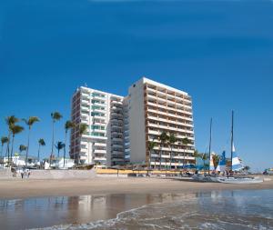 马萨特兰拉斯弗洛雷斯海滩度假村酒店的两座棕榈树海滩上的高楼