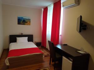 巴亚马雷Hotel New的一间卧室配有床、书桌和红色窗帘