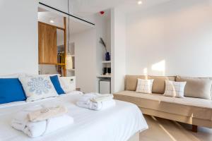 米克诺斯城布鲁托比亚套房住宿加早餐旅馆的卧室配有白色的床和沙发
