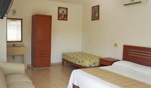 曼萨尼约马里卡门酒店的一间卧室配有两张床和梳妆台。