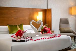迪拜迪拜朱美拉罗塔纳酒店的床上有两只天鹅和鲜花