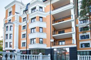 斯韦特洛戈尔斯克Apartments Alt Platz的一座橙色和白色的建筑,设有围栏