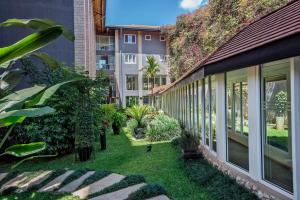 内罗毕Best Western Nairobi Upper Hill的一座种有植物和树木的建筑的庭院