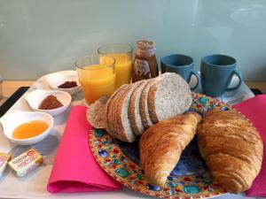 里尔卢米埃住宿加早餐旅馆的桌上放着一盘面包和羊角面包
