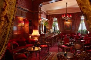巴黎拉斐尔酒店的一间设有酒吧的客房,配有红色的椅子和桌子