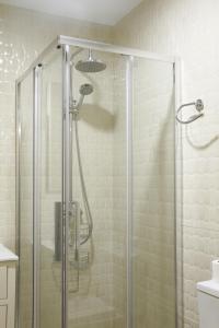 科尼尔-德拉弗龙特拉Hostal Flor De Lis- Lojo的浴室里设有玻璃门淋浴