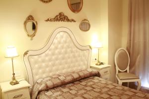 科尼尔-德拉弗龙特拉Hostal Flor De Lis- Lojo的一间卧室配有一张床、两盏灯和一把椅子