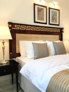 华沙Luxury Apartments MONDRIAN Market Square III的卧室配有白色的床和木制床头板