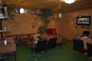 瑞诗凯诗拉吉宫酒店的客厅配有沙发、椅子和电视