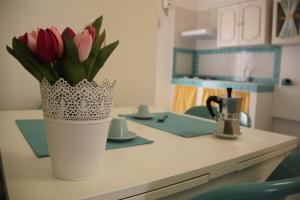 塔兰托Casa Vacanze Stella Maris的坐在厨房柜台上的粉红色郁金香花瓶