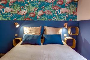 尼斯卡萨尼萨特公寓的一间卧室配有一张蓝色的墙壁和一张带火烈鸟的壁纸。