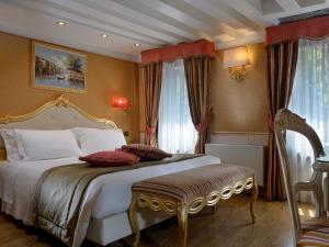 威尼斯Hotel Olimpia Venice, BW Signature Collection 3sup的一间卧室配有一张金色床架的大床
