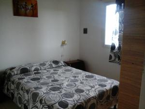 Las CompuertasCabañas Del Sol的一间卧室配有一张带黑白色棉被的床