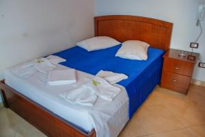 培拉特Hotel Shpella的床上铺有蓝色床单和白色毛巾