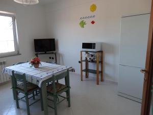 贡内萨Appartamento La Collinetta的厨房配有桌子和冰箱