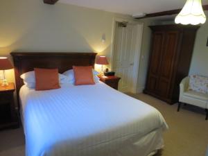 MellorPack Horse Inn的卧室配有一张带两个橙色枕头的大白色床