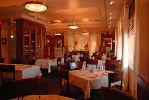 七岛市Hôtel Mingan的餐厅配有桌椅和白色桌布