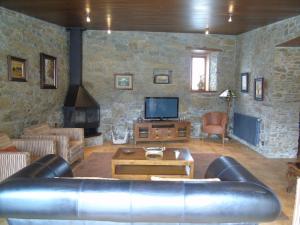 PaleoCasa da Paioca的客厅配有真皮沙发和电视
