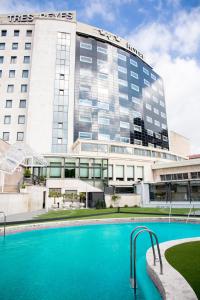 潘普洛纳Hotel Tres Reyes Pamplona的大楼前设有游泳池的酒店