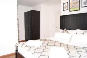 威斯巴登默克尔别墅公寓的一间卧室设有两张床和黑色床头板