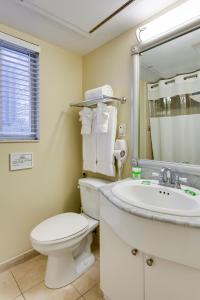 迈阿密海滩太阳海港精品酒店的一间带卫生间、水槽和镜子的浴室