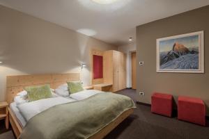 圣洛伦佐-迪塞巴托特劳伯酒店的一间卧室配有一张大床和红色椅子