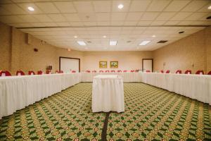 特拉弗斯城海岸度假酒店的宴会厅配有白色桌子和红色椅子