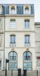 波尔多L'annexe Bordeaux Traditions的一座大型石头建筑,设有窗户和门