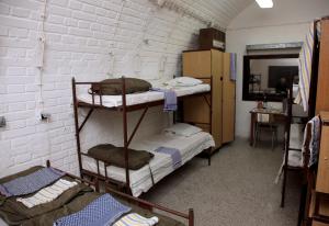 布尔诺10-Z地堡旅舍的带三张双层床和镜子的客房