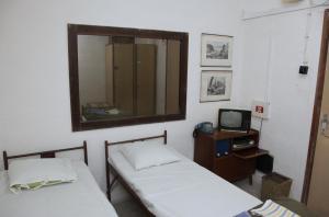 布尔诺10-Z地堡旅舍的配有镜子和电视的客房内的两张床