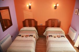 BernedoCasa Rural Gaztelubidea的橙色墙壁客房的两张床
