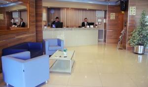 雷乌斯雷乌斯公园酒店的大厅,两个男人坐在办公室的柜台上