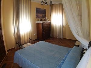 埃尔博斯克Casa Rural Entreparques的一间卧室配有蓝色的床和梳妆台