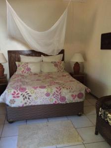 利文斯顿塔伯尼娜旅馆的一间卧室配有一张带粉色和白色床单及枕头的床。