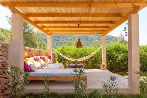 卡拉瓦德亚Villa Es Coral的一张位于带吊床的木制凉棚下的床铺