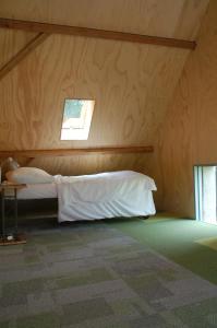 多尔恩克莱因杜布林酒店的木制客房内的一间卧室,配有一张床