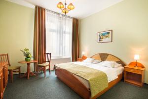 布达佩斯布达佩斯巴罗斯城市酒店的酒店客房带一张床、一张桌子和椅子