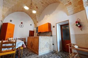 奥里亚casa vacanze Filomena的厨房设有拱形天花板和桌椅