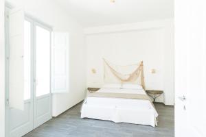 普尔萨诺唐格拉姆酒店的白色的卧室设有床和窗户