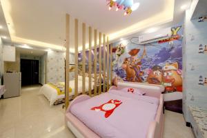 广州星悦遵品公寓长隆北门店的一间卧室设有两张床和一堵带微型老鼠壁画的墙壁