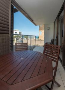 卡伦德拉梅里玛苑假日酒店的阳台的甲板上配有木桌和椅子