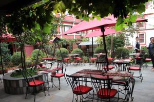 加德满都遇见尼泊尔&spa酒店的一组配有粉红色伞的桌椅