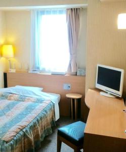鹿儿岛鸭池广场酒店的酒店客房配有一张床和一张带电脑的书桌