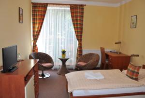 利特威诺夫劳茨基酒店的酒店客房配有床、椅子和电视。