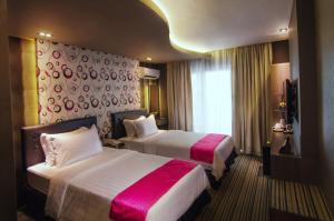 麦克坦Eloisa Royal Suites的酒店客房设有两张床和窗户。