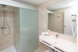 埃斯卡纳Typic Art的带淋浴、盥洗盆和镜子的浴室